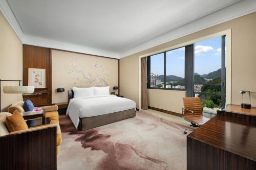 - une chambre avec un lit et une grande fenêtre dans l'établissement Crowne Plaza Huangshan Yucheng, an IHG Hotel, à Huangshan