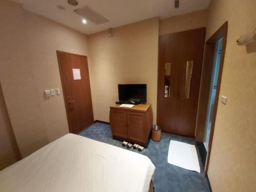 a hotel room with a bed and a television at Beautyage Spring Hotel in Taipei