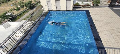 a person swimming in a large swimming pool at Clover Inn in Udaipur