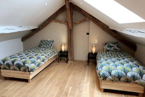 a bedroom with two beds and two lamps in it at Au bord du Ny in Hotton