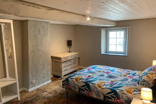 a bedroom with a bed and a dresser and a window at Au bord du Ny in Hotton