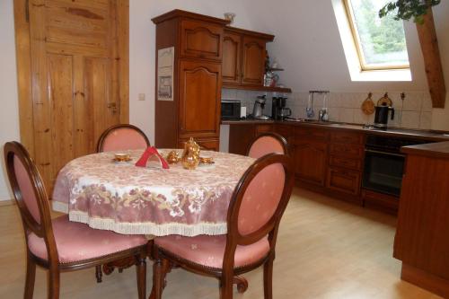 una cocina con una mesa con sillas rosas y una cocina con en Villa Biso, en Solingen