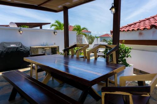 una mesa de madera y sillas en un patio en Paseo del Sol Surf B 301 condo, en Playa del Carmen