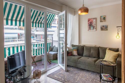 een woonkamer met een bank en een tv bij ´La Primavera ´ in Roquebrune-Cap-Martin