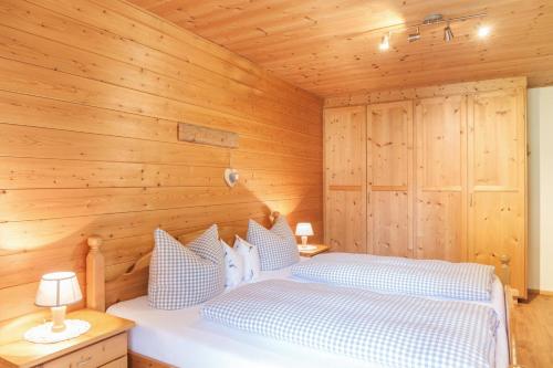 Ferienwohnung Alpenrose في غرينو: غرفة نوم بسرير مع جدار خشبي