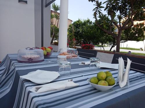 B&B Villa dei Desideri في برايا إيه ماري: طاولة زرقاء وبيضاء مع صحن فاكهة