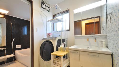 ein Badezimmer mit einem Waschbecken und einer Waschmaschine in der Unterkunft Sunshoen Akaishibeach in Hirakubo