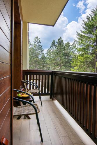 a balcony with a chair and a view of trees at Hotel Agape in Zlatibor
