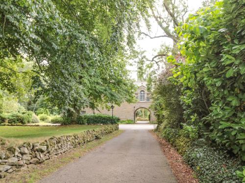 a path in front of a house with a stone wall at The Coach House in Allanton