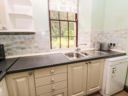 a kitchen with a sink and a window at The Coach House in Allanton