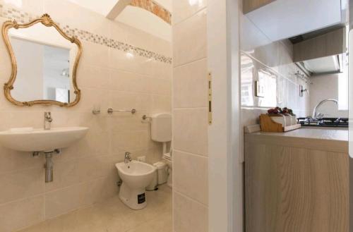 a bathroom with a sink and a toilet and a mirror at Historical Apartments By Seaside in Viareggio