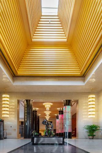 a lobby with a yellow ceiling and a building at Grand Millennium Beijing in Beijing