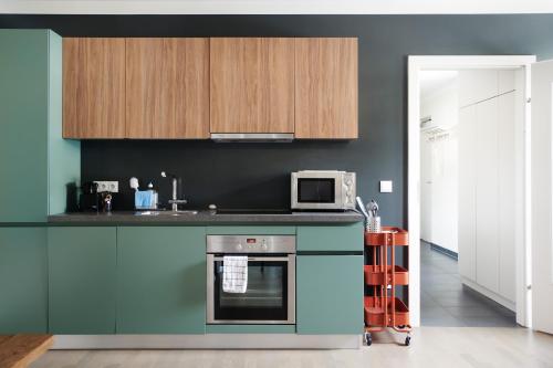 a kitchen with a stove and a microwave at HOMEBOUND APARTMENTS Salzburg City II - contactless check-in in Salzburg