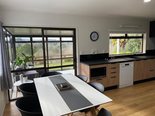 a kitchen with a table and chairs and a clock at Modern apartment- rural outlook, central Cambridge in Cambridge