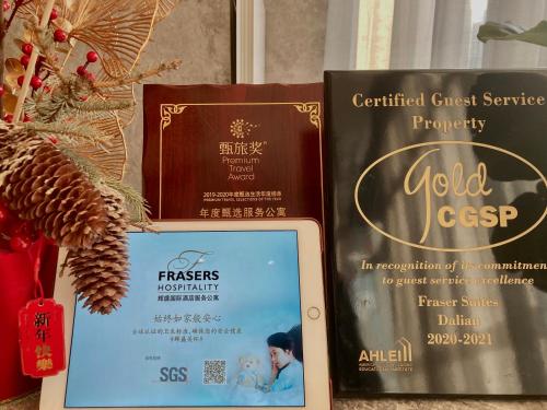 three books are sitting next to a christmas tree at Fraser Suites Dalian in Dalian