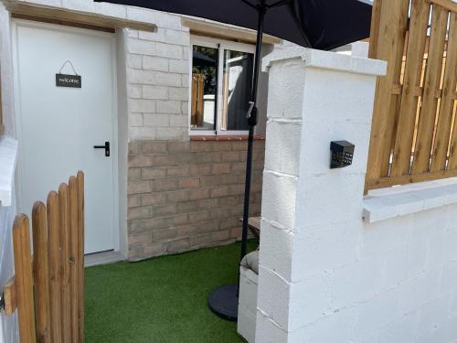 an umbrella stands next to a house with a door at Estudios Eucalyptal El Palmar a 100 m del mar in El Palmar