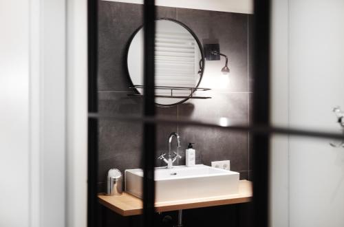 a bathroom with a white sink and a mirror at HOMEBOUND APARTMENTS Salzburg City II - contactless check-in in Salzburg