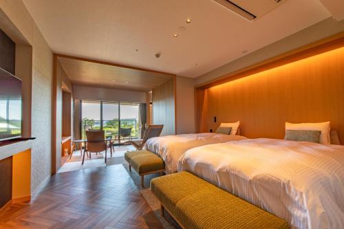 a hotel room with two beds and a table and chairs at Matsushima Ichinobo in Matsushima