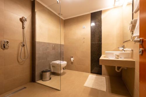 a bathroom with a shower and a toilet and a sink at Apollonia Hotel Gevgelija in Gevgelija