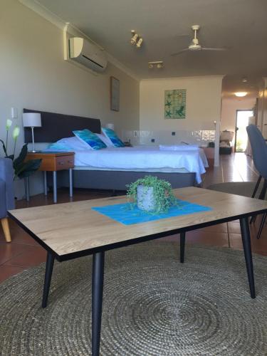 Elliott Heads的住宿－Villa 21 The Coral Cove Resort，卧室前配有一张床和一张桌子