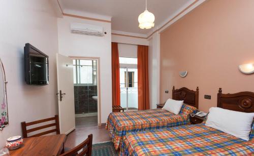Ένα ή περισσότερα κρεβάτια σε δωμάτιο στο Hôtel Astrid