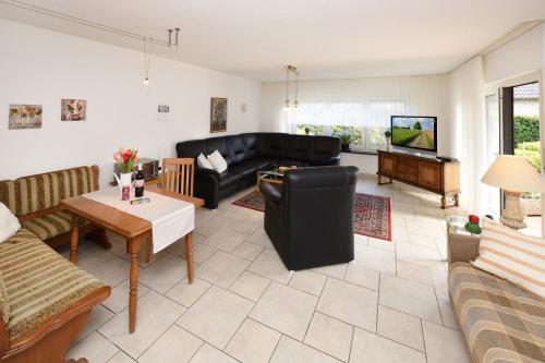 a living room with a black couch and a table at Haus Wegener in Bad Sassendorf