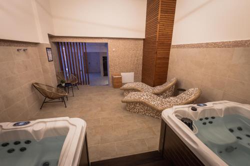 a bathroom with two sinks and a tub in a room at Apollonia Hotel Gevgelija in Gevgelija