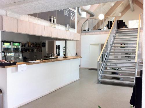 a kitchen with a counter and a staircase in a room at Tollundgaard Golf Park & Apartments in Funder Kirkeby