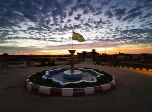 a green flag on top of a fountain in a parking lot at Hotel Aljazira in Nouadhibou