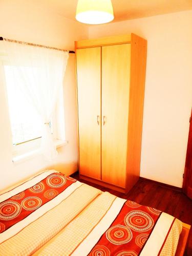 a bedroom with a bed with a cabinet and a window at Romantická chalupa pod Vysokými Tatrami in Liptovský Hrádok