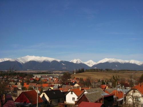 a town with snow capped mountains in the background at Romantická chalupa pod Vysokými Tatrami in Liptovský Hrádok