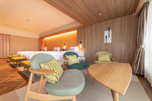 a hotel room with a bed and chairs and a table at Matsushima Ichinobo in Matsushima