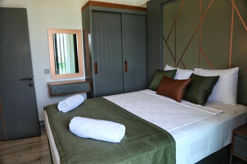a bedroom with a large bed with two pillows on it at Güven Park Residance & Apart Hotel in Kemer