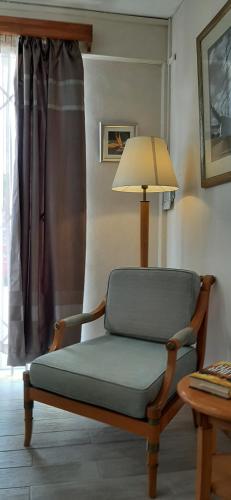 a chair in a living room with a lamp at Villa de luxe avec piscine a 200m de la plage in Flic-en-Flac