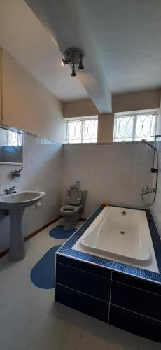 a bathroom with a tub and a toilet and a sink at Villa de luxe avec piscine a 200m de la plage in Flic-en-Flac