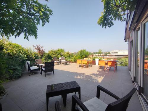a patio with chairs and tables and a table and chairs at Nuova Opera Rooms in Verona