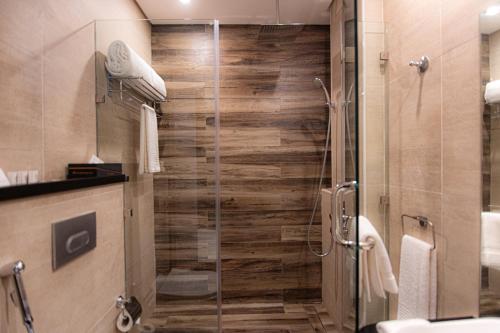 baño con ducha y puerta de cristal en Swiss-Belinn Sharq, Kuwait, en Kuwait