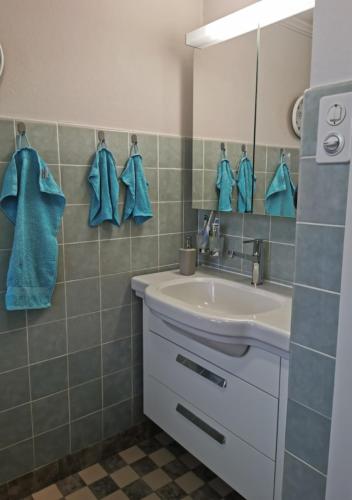 y baño con lavabo, espejo y toallas azules. en NEB-THUN LODGE`s Seehaus 1 Gwatt, en Thun