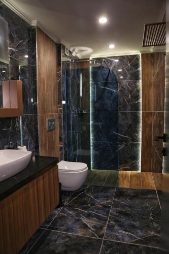a bathroom with a sink and a toilet and a shower at Güven Park Residance & Apart Hotel in Kemer