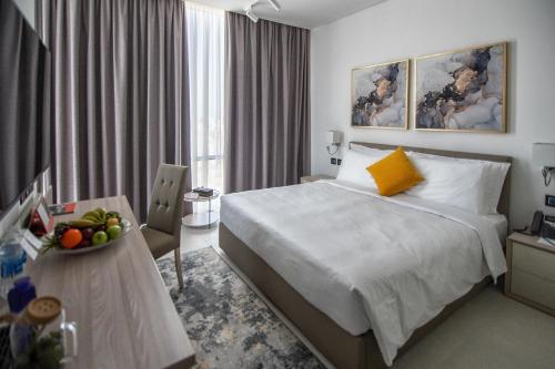 a hotel room with a bed and a table with a bowl of fruit at Swiss-Belinn Sharq, Kuwait in Kuwait
