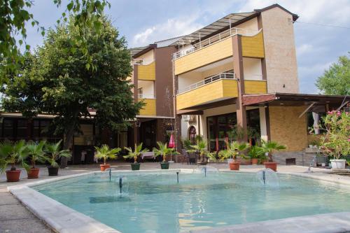 um hotel com piscina em frente a um edifício em Hotel Fantazia em Haskovo