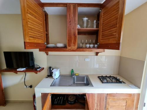 a small kitchen with a sink and a stove at Boracay Amor Apartment in Boracay