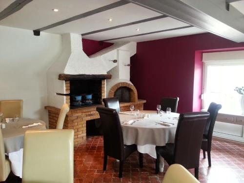 a dining room with a table and a fireplace at AUBERGE DU CANAL in Houdelaincourt