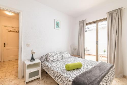 a bedroom with a bed with a yellow pillow on it at alquilaencanarias El Medano Playa El Cabezo in El Médano