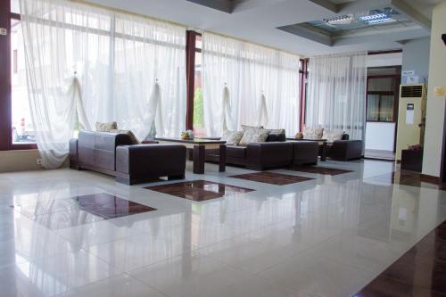 a large living room with couches and a table at Hotel Fantazia in Haskovo