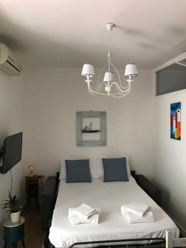 - une chambre avec un lit et un lustre dans l'établissement Titti e Nonna, à Naples