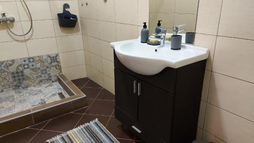 a bathroom with a white sink and a shower at Apartment Bascarsija in Sarajevo