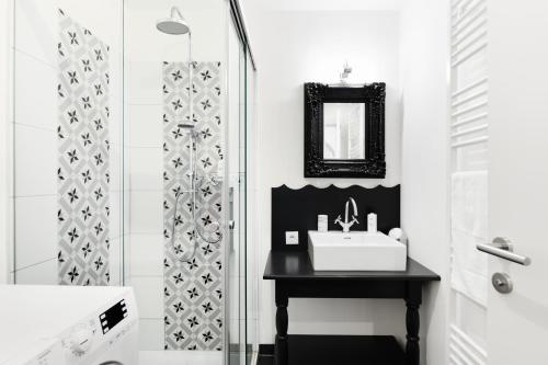 a black and white bathroom with a sink and a shower at HOMEBOUND APARTMENTS Salzburg City II - contactless check-in in Salzburg