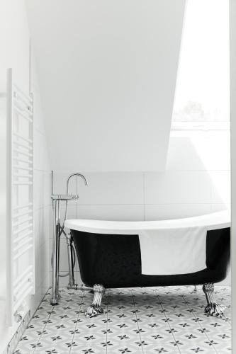 a black and white bathroom with a bath tub at HOMEBOUND APARTMENTS Salzburg City II - contactless check-in in Salzburg