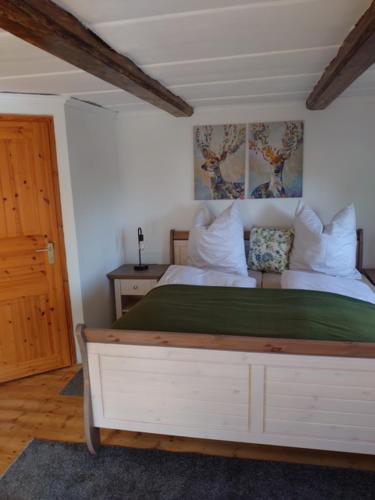 a bedroom with a white bed and a wooden door at Historisches Aschberg Haisl Klingenthal, Terrasse, großer Garten 6 plus 2 Personen in Klingenthal